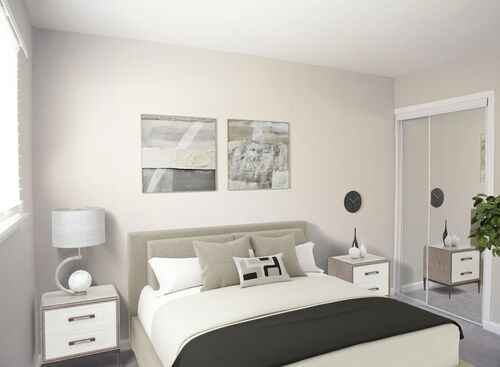 Bedroom furnished with white and grey furniture with sunlight from a nearby window