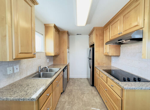 Spacious kitchen with wooden cabinets granite countertops and stainless steel appliances