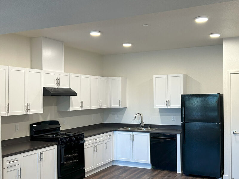 Image of kitchen with white cabinets and black appliances