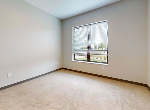 Bedroom with large window in loft apartment at Lofts at 128