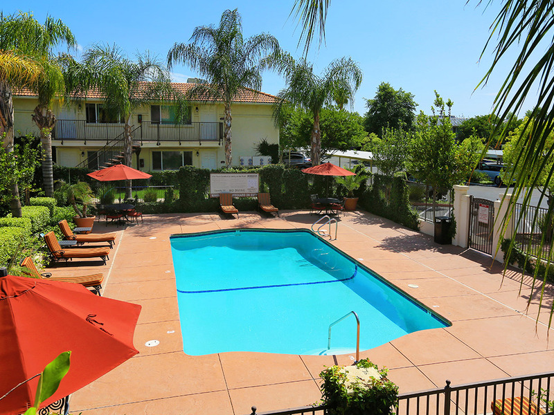 Swimming pool with umbrellas and lounge chair seating.