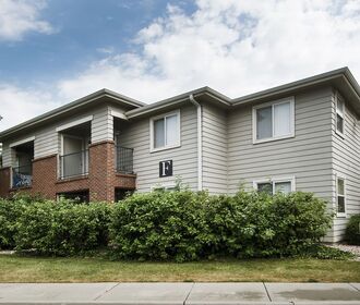 Exterior view of apartment building with patio and beautiful landscaping