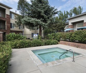 Hot tub with greenery and apartments in the background