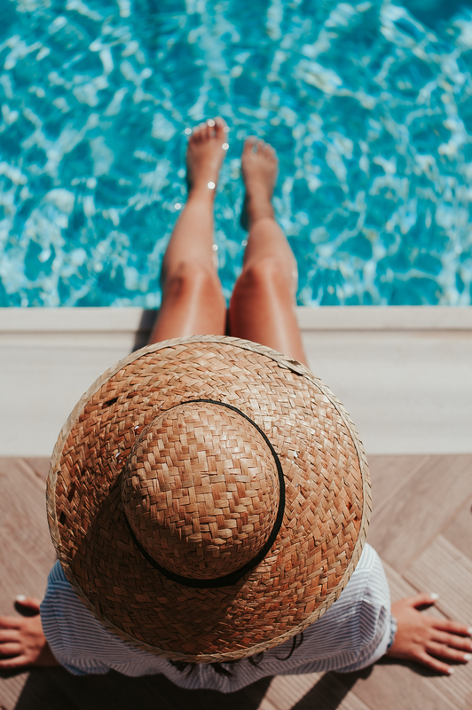 Stock image of a person sitting on the edge of the swimming pool