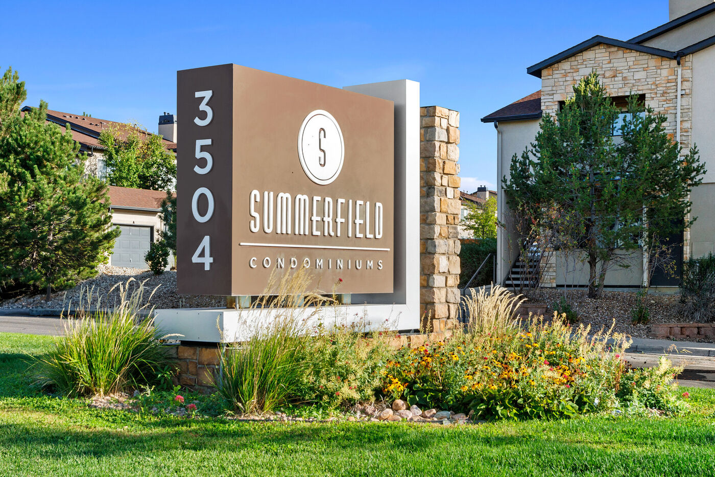 Summerfield - Image of the front entranced monument sign sitting in a bed of flowers.