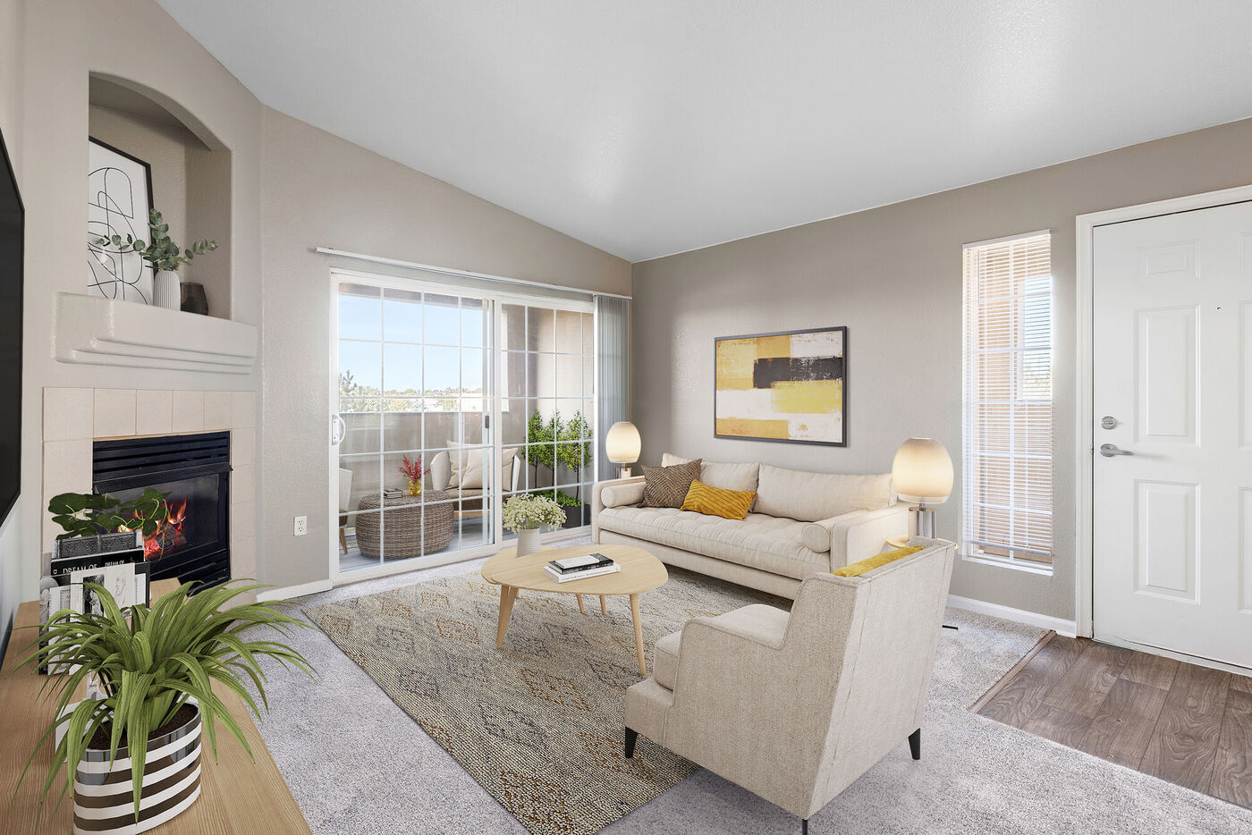 Summerfield - Image of the model apartment living area with a couch, coffee table, and a view of the patio.