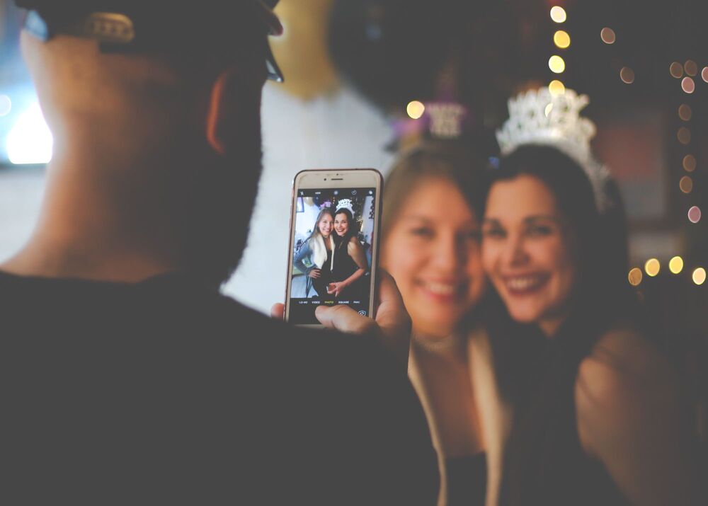 stock image of someone taking a picture of two women standing together